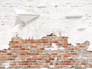 纸飞机飞在斑驳砖墙上