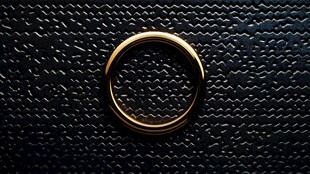 金色戒指置于黑色纹理面