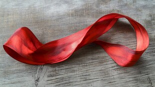 红色绸带优雅卷曲于木面