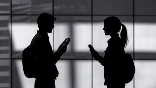 男女在室内专注看手机