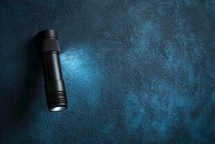 黑色手电筒照亮蓝色背景