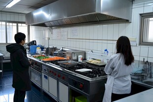 厨房内两人专注烹饪场景