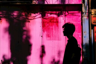 粉色墙前的孤独男子剪影