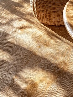 木质地板上的光影与藤编物