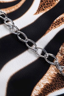 银色链条置于斑马纹皮革上