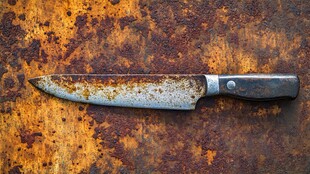 生锈刀具置于斑驳锈迹表面