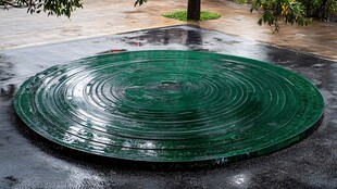 圆形绿色井盖及周边景象