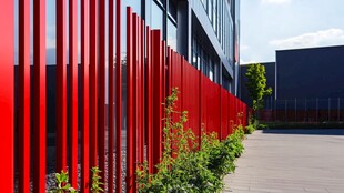 红色金属围栏旁的绿植景观