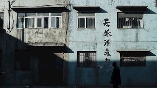 老旧建筑前的孤独身影