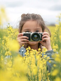 女孩在花田持相机拍照