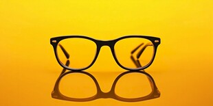 黄色背景上的时尚黑框眼镜