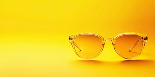 黄色背景上的时尚透明墨镜