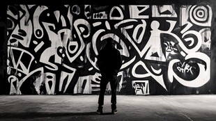 人立于黑白涂鸦墙前