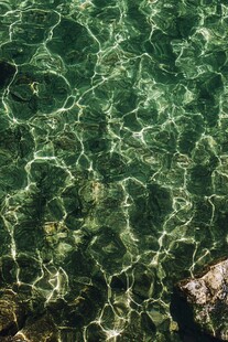 清澈绿水中的波纹与石块