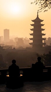 夕阳下古塔前的静谧身影