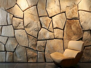 石纹墙面旁的舒适单人椅