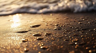 夕阳下沙滩上的海浪与水珠