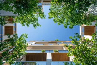 仰望绿植环绕的现代建筑