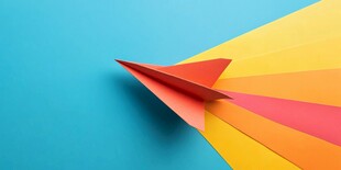 彩色纸飞机在蓝背景起飞