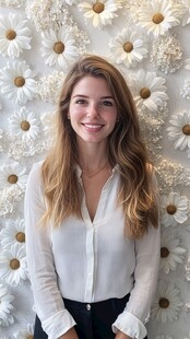 女子浅笑于雏菊墙前