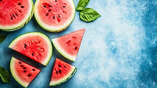 蓝底上的鲜切西瓜及绿叶