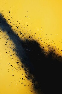 黄色背景上的黑色粉末飞溅
