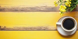 黄色木桌上的咖啡与小花