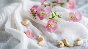 粉色小花与腰果静置于布上