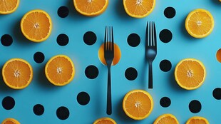 蓝色背景上的橙子与叉子