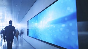 商务人士于科技大屏旁行走