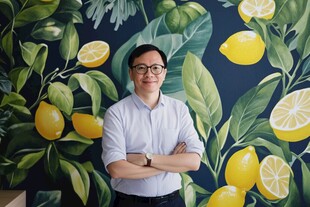 男子立于柠檬绿植壁画前