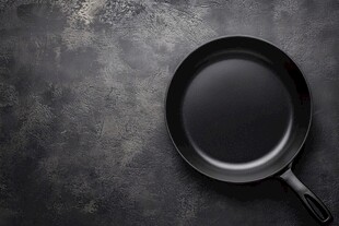 黑色平底锅置于粗糙台面