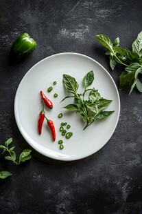 白盘上的新鲜辣椒与香草
