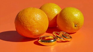 橙色背景下的橙子与金戒指
