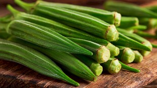 新鲜秋葵摆放在木砧板上