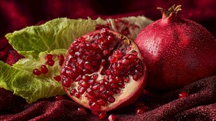 红布上的鲜石榴与生菜