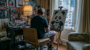 画家专注创作可爱熊猫画作