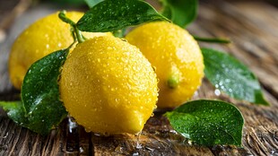 新鲜带叶柠檬置于木桌