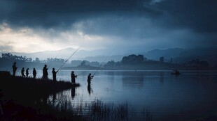 湖畔暮色中众人垂钓之景